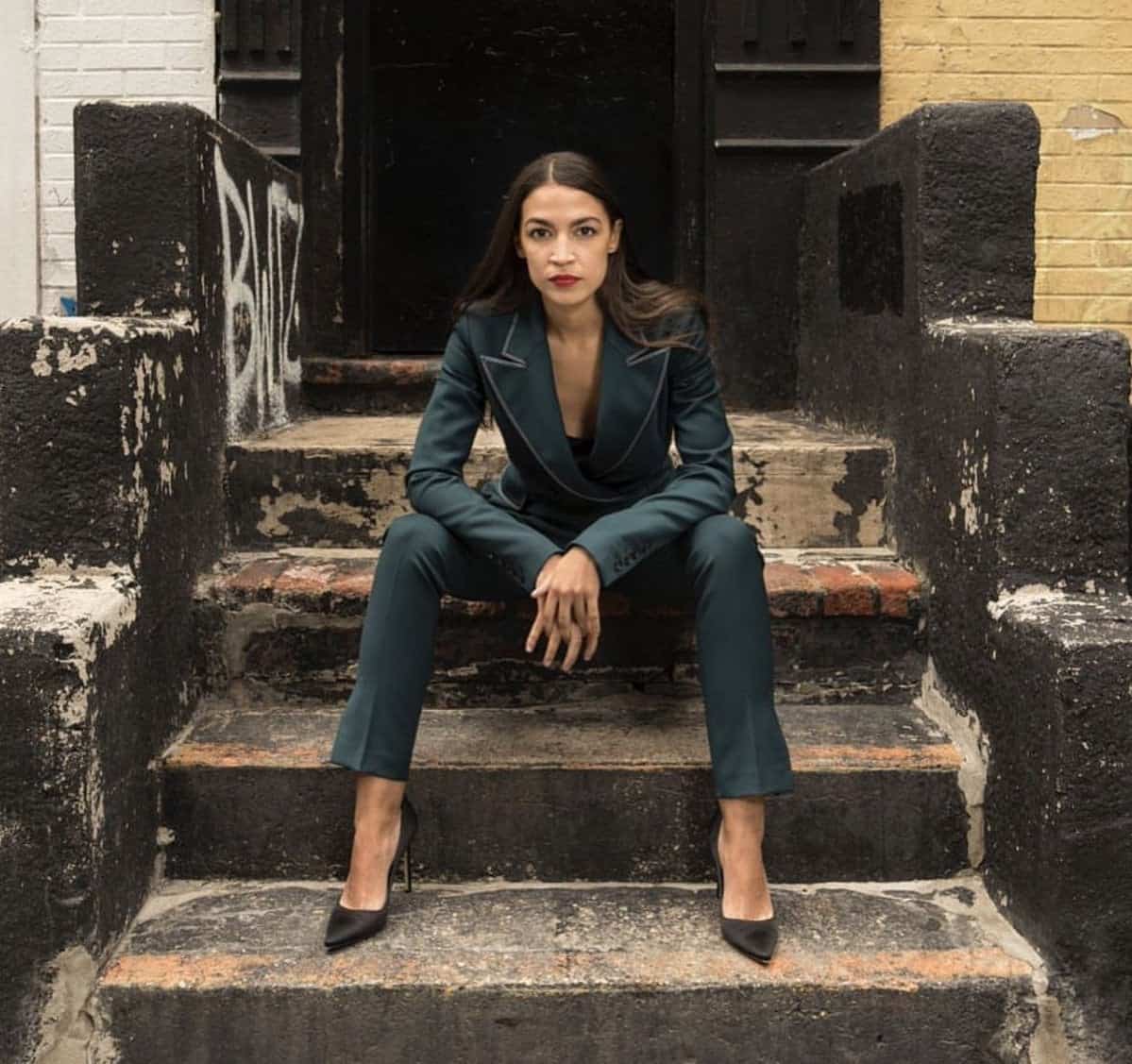 Okay, here's an analysis of the photograph of Alexandria Ocasio-Cortez (AOC) based on the requested theoretical frameworks. It's important to note that applying complex theories to a single image always involves inter...