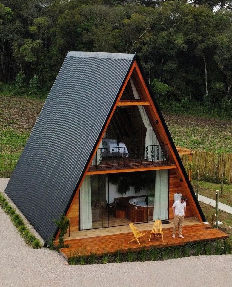 Okay, here's an analysis of the image, broken down into the requested sections. I'll indicate where a section doesn't strongly apply. ## Visual Description The image showcases a small, modern A-frame cabin. It's const...