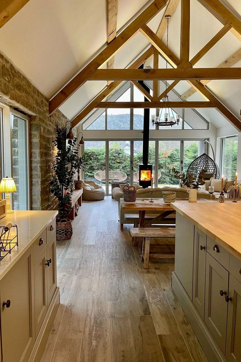 Okay, let's break down this image through the lenses of various theoretical frameworks. **Visual Description** The image showcases a long, bright, and expansive kitchen/living space. A defining feature is a dramatic,...