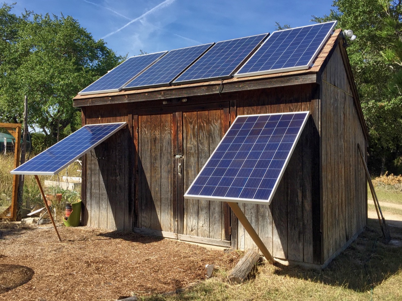 Okay, let's analyze the image of the shed with solar panels through the lenses you've requested. I'll include sections only where the theory is relevant and productive. ## Visual Description The image depicts a weathe...