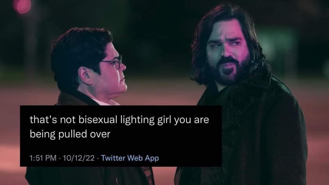 Okay, let's break down this image and text using the requested theoretical lenses. **Visual Description** The image shows a still from the television show *What We Do in the Shadows*. Two men are in the foreground. On...