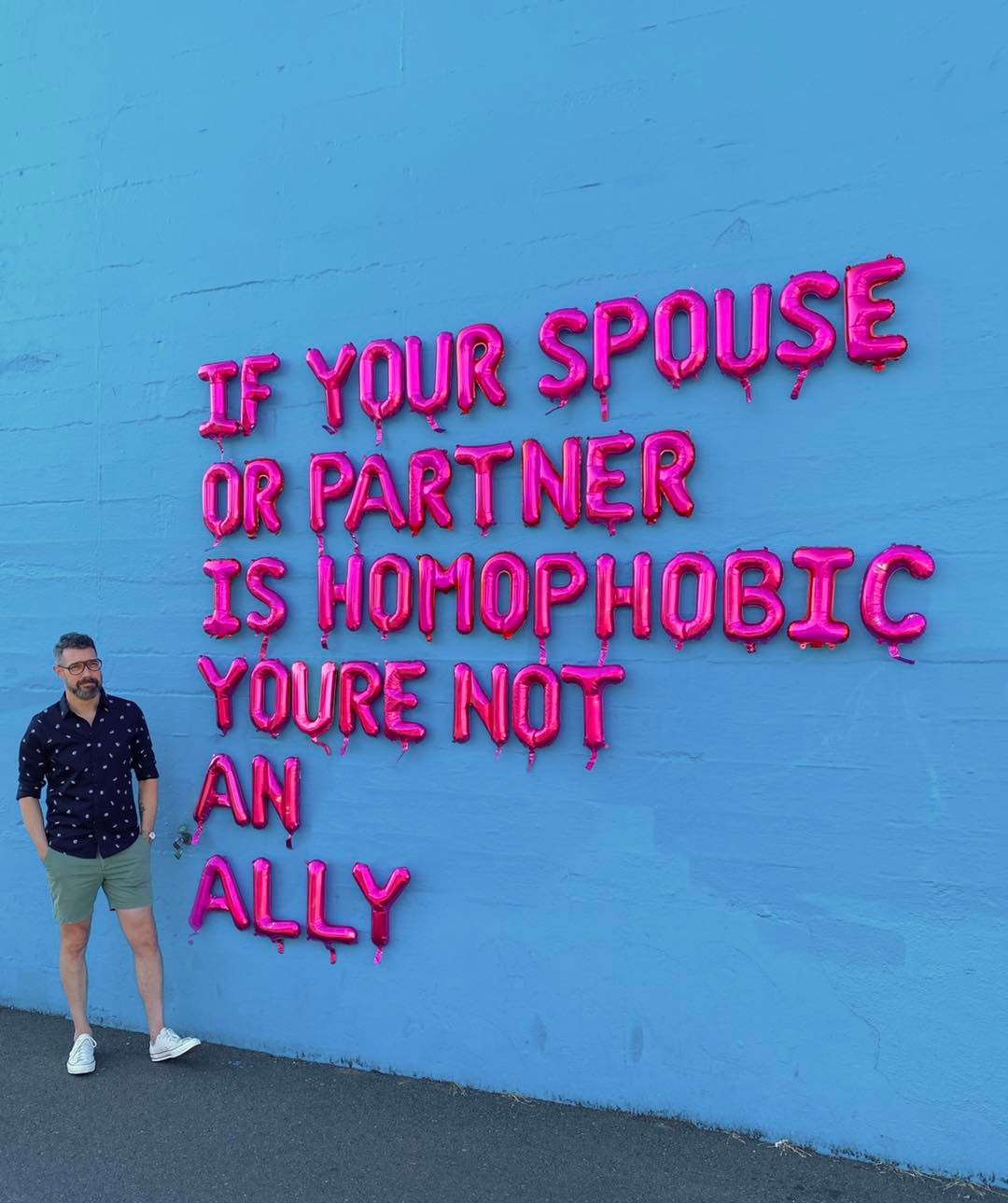 Okay, here's an analysis of the image, broken down into sections based on the requested theoretical frameworks, applying them where relevant. ## Visual Description The image features a vibrant blue wall with pink, bal...