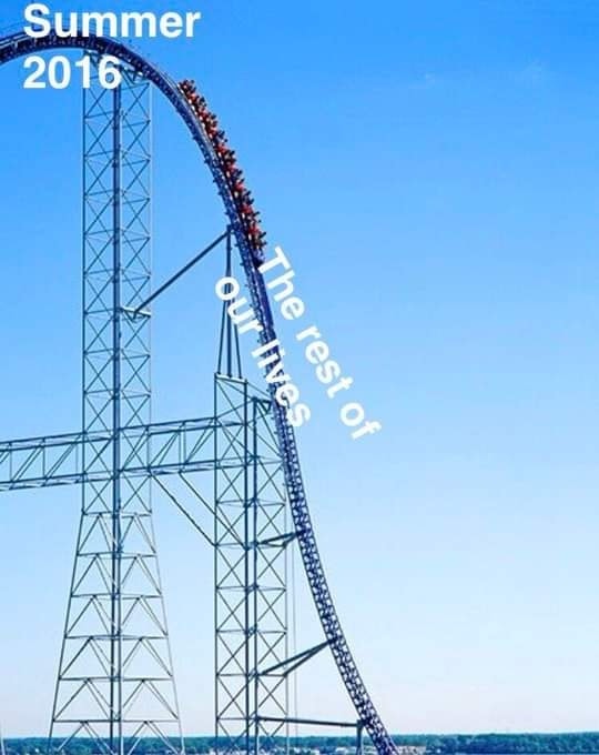 Okay, let's analyze the image through the lenses you've provided. **Visual Description** The image depicts a tall, steel roller coaster against a bright blue sky. The coaster is in motion, with a line of brightly colo...