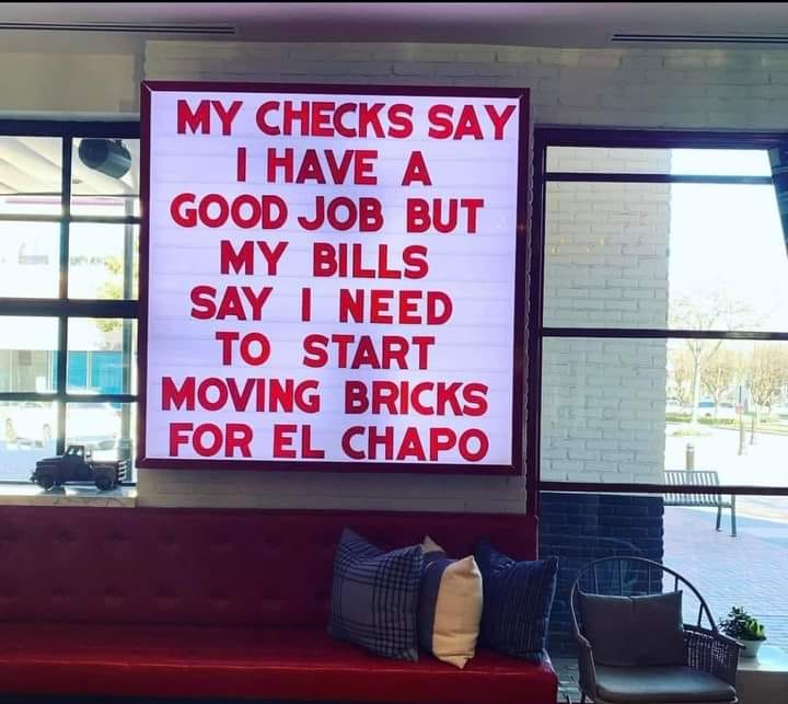 Okay, let's break down this image, analyzing it through the requested theoretical lenses. **Visual Description** The image depicts a large, bright red poster with white text. The text reads: "MY CHECKS SAY I HAVE A GO...