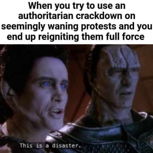 Okay, let's break down this meme using the requested theoretical frameworks. **Visual Description** The image is a still from the 2000 film *Gladiator*. It depicts two Roman senators, Cassius (the one speaking) and Gr...