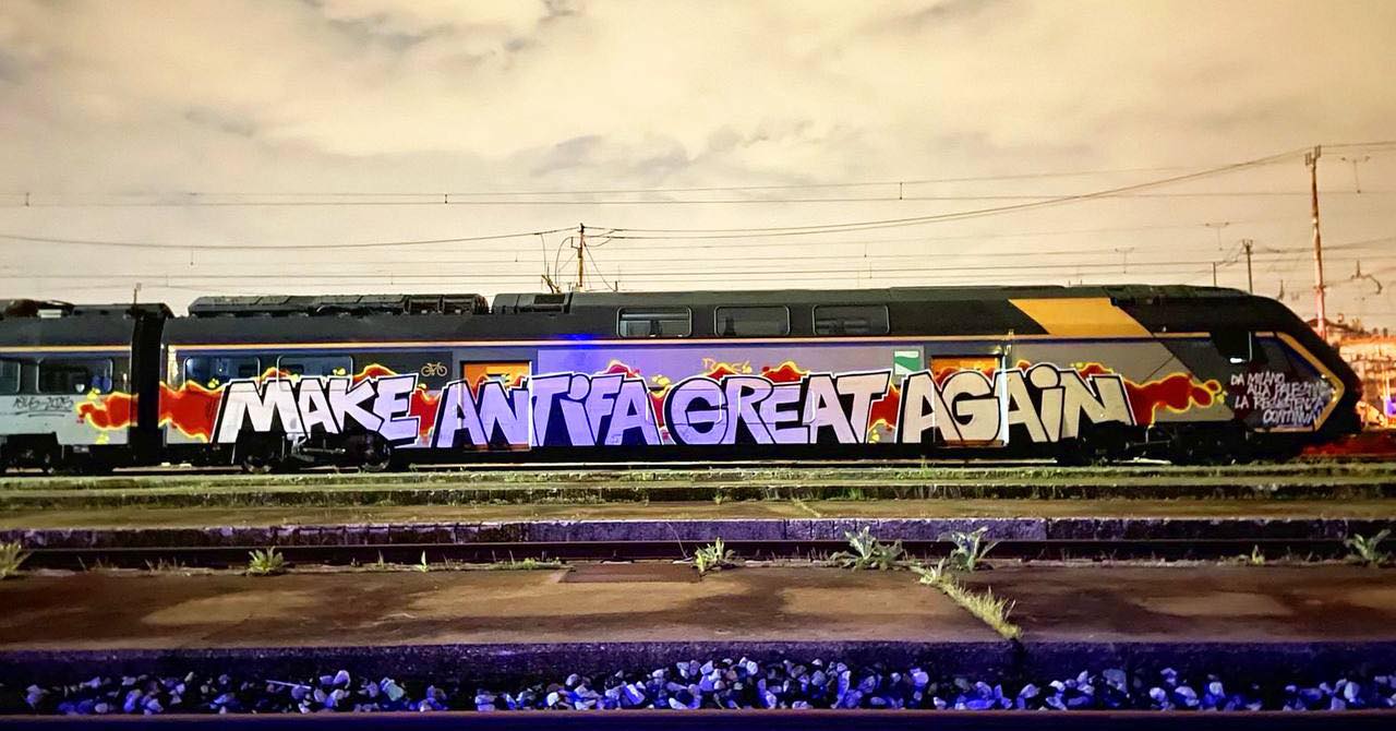 Okay, here's an analysis of the image broken down into sections as requested, focusing on applicable theoretical frameworks. **Visual Description** The image depicts a long, black passenger train covered in graffiti....