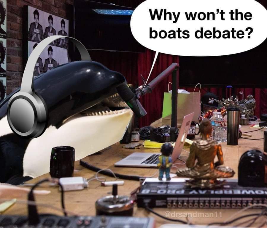 This meme is a humorous take on the anti-fascist movement, specifically the "Boats" debate, a joke about the absurdity of a serious discussion about the topic of boats. The image features a giant orca whale wearing he...