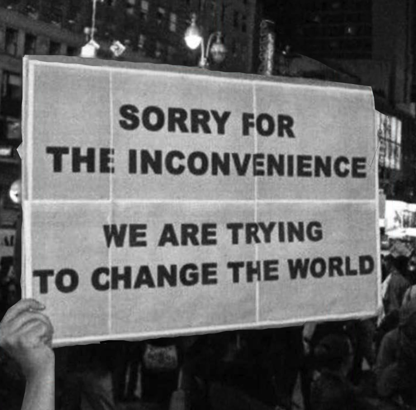 Okay, let's break down this image using the lenses you've requested. **Visual Description** The image is a black and white photograph capturing a protest sign held aloft in a crowd. The sign is rectangular, appearing...