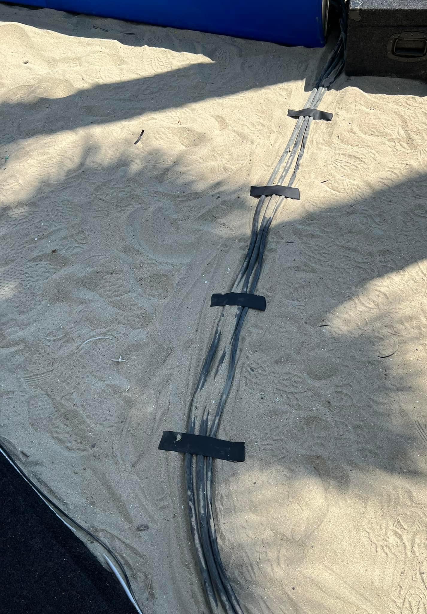 Okay, let's break down the image through various theoretical lenses. **Visual Description** The image depicts a section of what appears to be a beige or light-colored tarp or fabric surface. A dark, wet line runs diag...