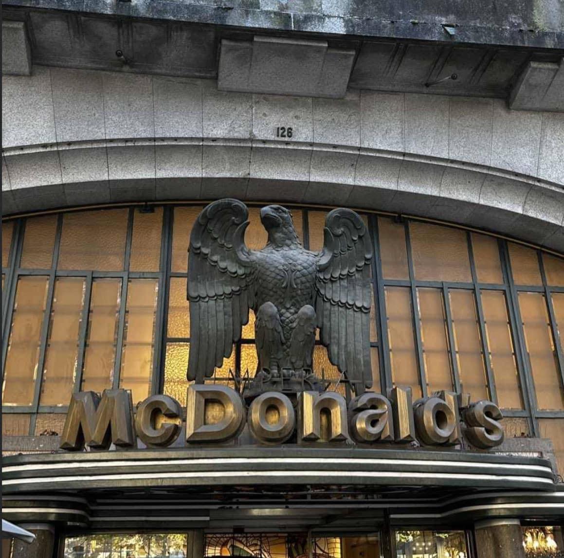 Okay, let's break down this image of a McDonald's entrance with a prominent eagle sculpture using the frameworks you've requested. Some sections will be more substantial than others, depending on the relevance to the...