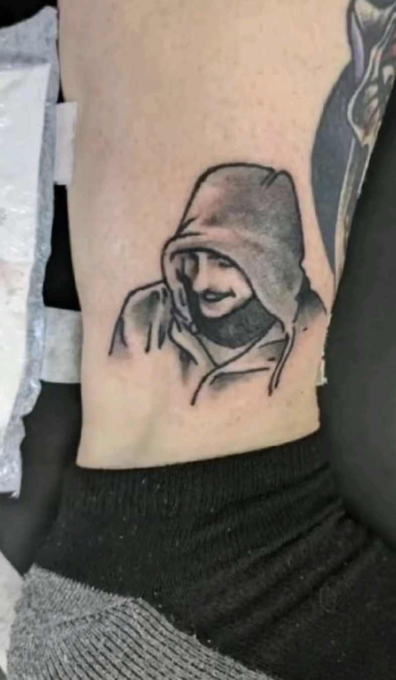 Okay, let's analyze the tattoo depicted in the image, considering the requested theoretical frameworks. Please note that these are interpretations based on a static image and limited context. **Visual Description** Th...