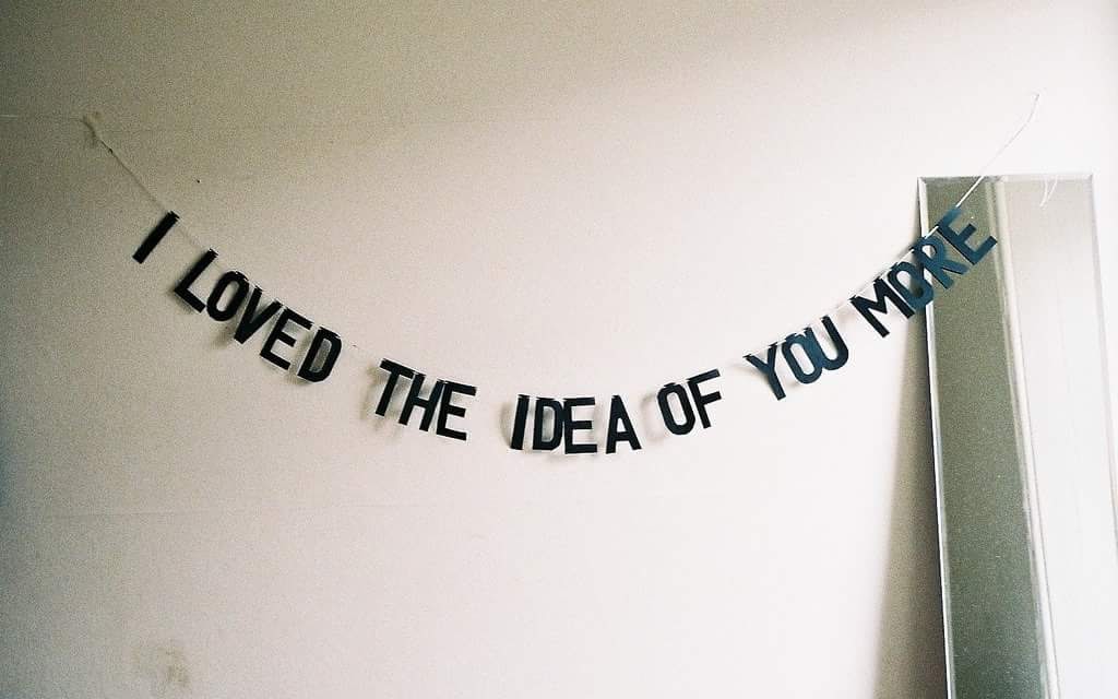 Okay, let's break down the image through the requested theoretical lenses. **Visual Description** The image features a banner or garland strung across a white wall. The banner is made up of individual black letter blo...