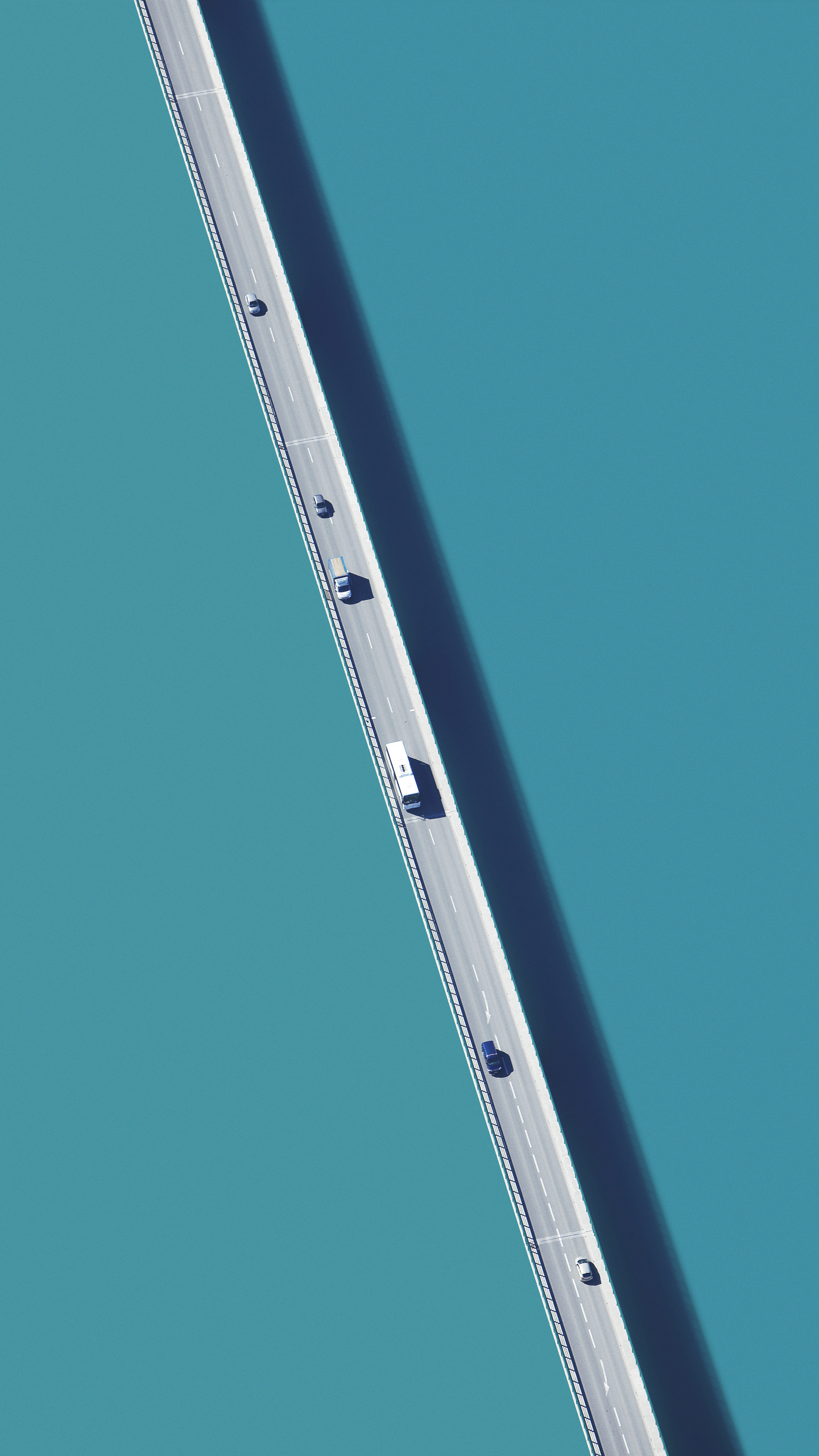 Okay, let's break down the image with analyses as requested, focusing on the topics that are meaningfully applicable. **1. Visual Description** The photograph is a high-angle, aerial view of a long, straight bridge ex...