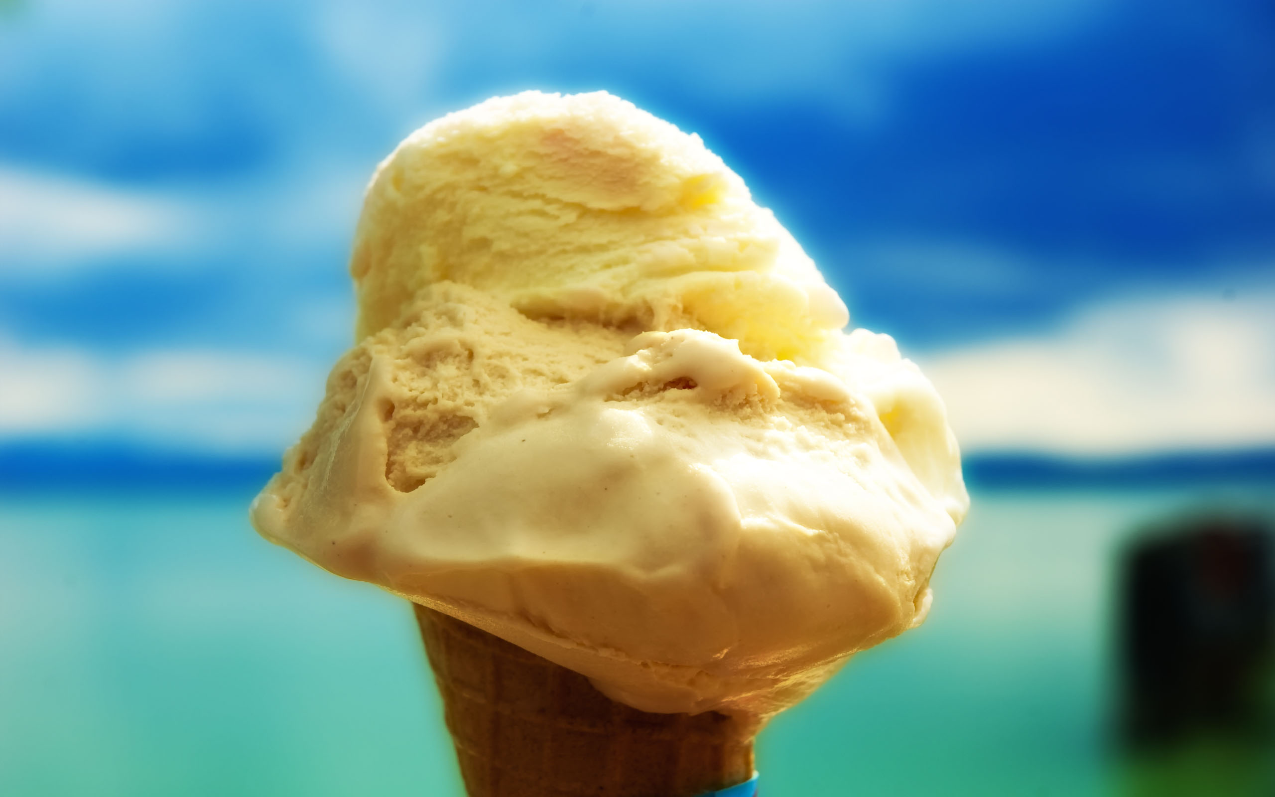 Okay, let's analyze this image of a melting ice cream cone through several theoretical lenses, where applicable. ## Visual Description The image features a soft-serve ice cream cone, held upright and prominently posit...