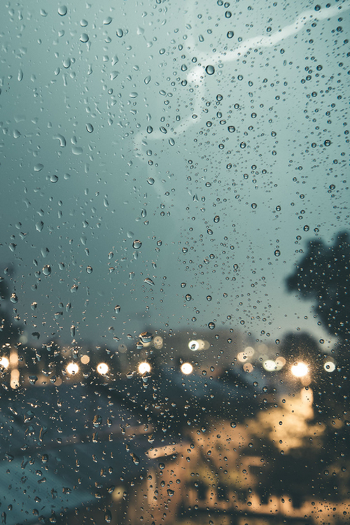 Okay, let's break down the image through the requested theoretical lenses. **Visual Description** The image depicts a view through a rain-streaked window. Numerous water droplets cover the glass, distorting the scene...