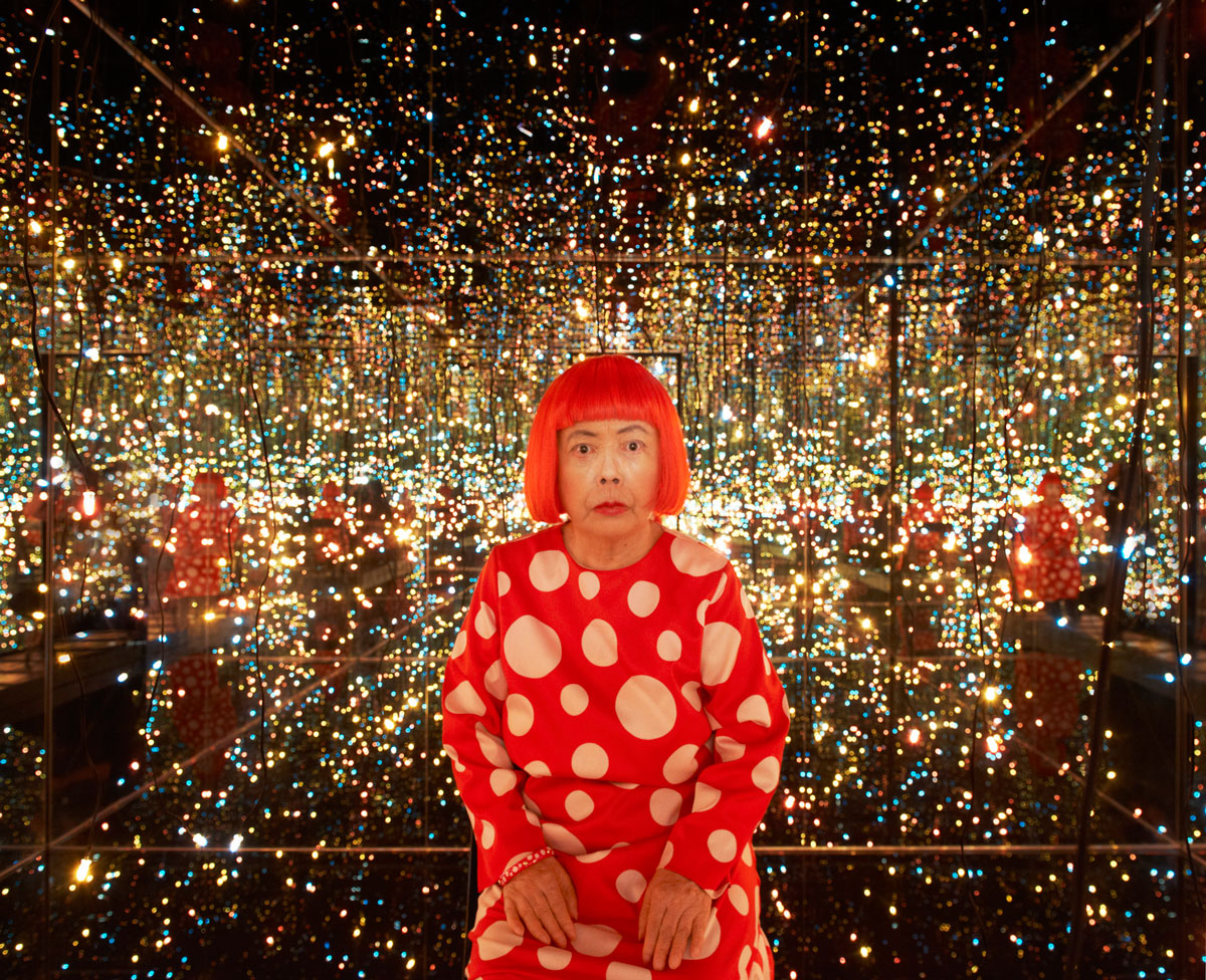 Okay, let's break down this image of Yayoi Kusama in one of her Infinity Mirror Rooms using the requested theoretical lenses. I'll only include sections relevant to the image's content and potential interpretations. *...