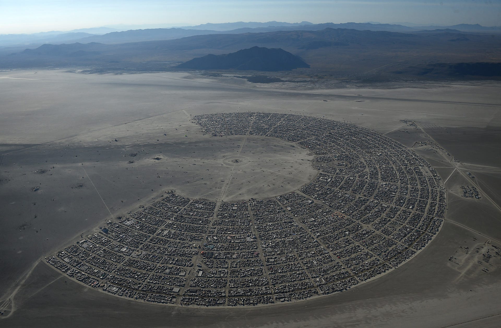 Okay, let's break down this image of Black Rock City (Burning Man) through various theoretical lenses. Given the nature of the image, several lenses are *very* applicable, while others are less direct. **1. Visual Des...