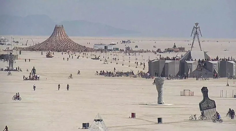 Okay, let's analyze the image of the Burning Man festival through various theoretical lenses. Given the visual nature of the scene, some lenses will be more fruitful than others. **Visual Description** The image depic...