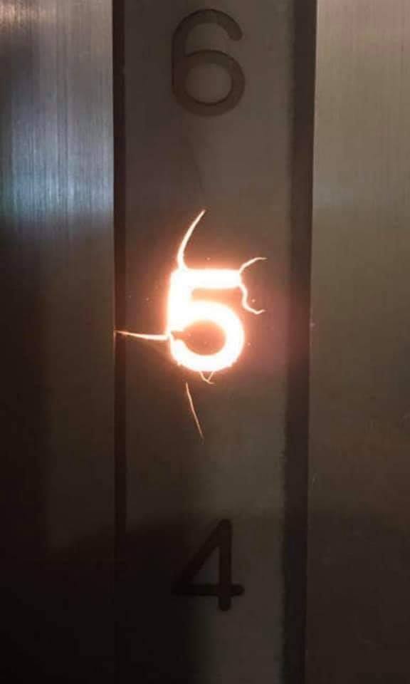 Okay, let's analyze the image with the requested theoretical frameworks. I will omit any section that doesn't particularly apply. **Visual Description** The image depicts a close-up view of a numbered elevator panel....