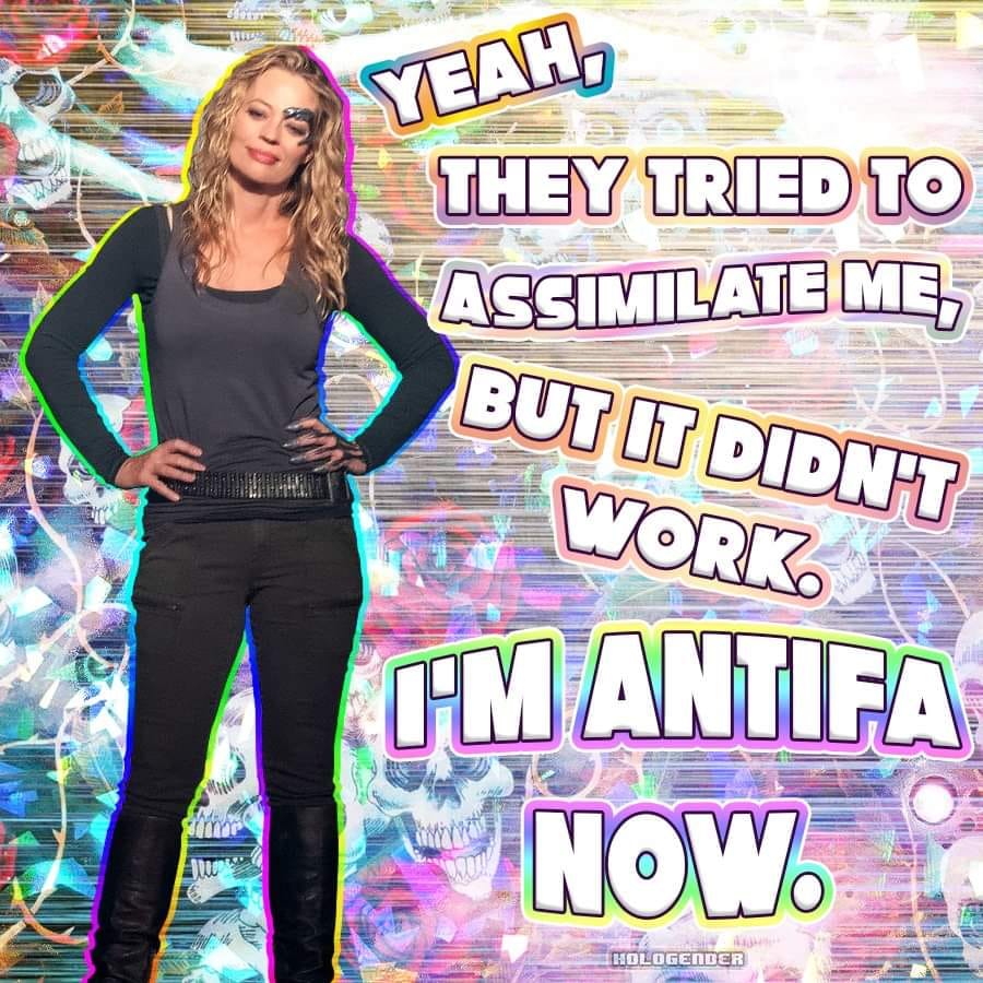 Okay, let's break down this image with the requested analytical lenses. It's a heavily layered image, ripe for deconstruction. ## Visual Description The image features a full-body shot of a white woman with blonde, cu...