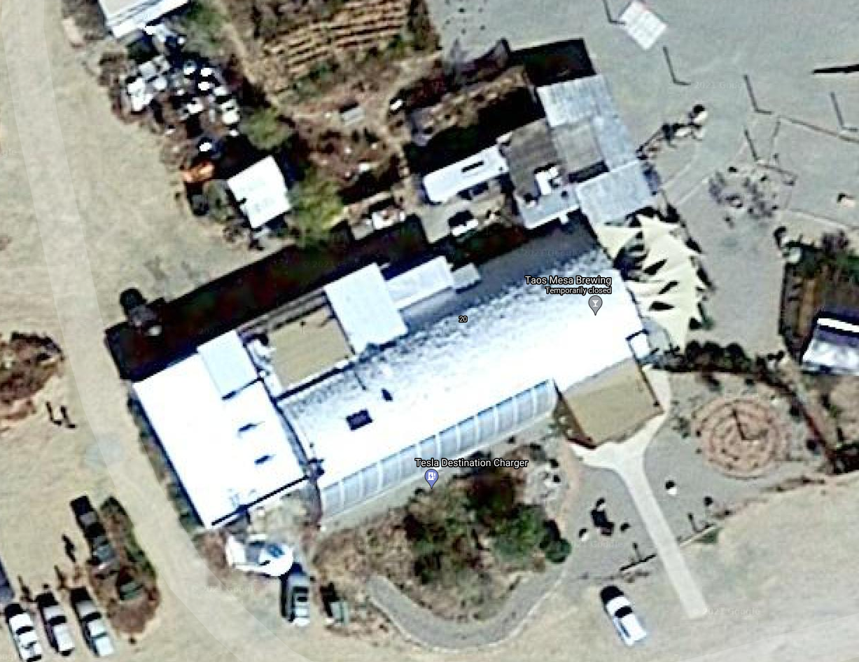 Okay, let's break down the aerial image of the Taos Mesa Brewing and Tesla Destination Charger location using the requested theoretical frameworks. I'll include sections only where the image lends itself to those anal...