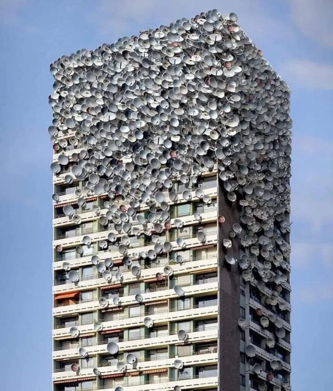 Okay, here's an analysis of the image of the building covered in satellite dishes, broken down into the requested sections. Note that some sections are stronger/more applicable than others. ## Visual Description The p...